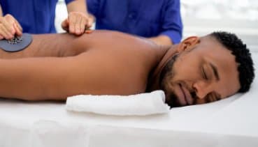 Ein Mann liegt entspannt auf einem Massagetisch und erhält eine Magnetfeldtherapie zur Schmerzlinderung und Entspannung.